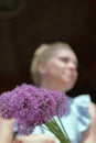 A waist portrait of a woman with a bouquet of wildflowers. Looks into the camera