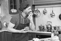 Impatient bearded cook tasting fresh broccoli at home kitchen