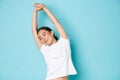 Waist-up of beautiful asian girl feeling relaxed and happy, close eyes and stretching hands sideways, feeling energized