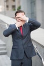 Waist up of entrepreneur hiding his face behind hands
