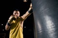 Athletic person in yellow shirt punching a bag