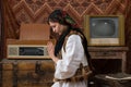 Waist up photo of a young woman in national white dress and black handkerchief who praying with closed eyes Royalty Free Stock Photo