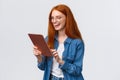 Waist-up porrtrait happy cheerful redhead girlfriend talking to partner using internet video-call service, laughing