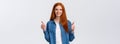 Waist-up portrait alluring confident smiling redhead female blogger review awesome new product, showing thumbs-up in