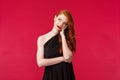 Waist-up portrait of annoyed and bored, bothered redhead woman in elegant black dress, sighing displeased, getting