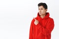 Waist-up portrait of asian angry man in red hoodie, frowning and grimacing, looking pointing judgemental, being Royalty Free Stock Photo