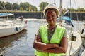 Black young woman wearing hardhat standing in yacht docks outdoors