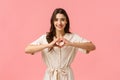 Waist-up portrait charming young brunette girl in dress, showing heart sign with love or care, absolutely adore Royalty Free Stock Photo
