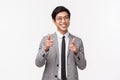 Waist-up portrait of cheeky, successful young asian office manager in suit, businessman searching for new employees