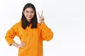 Waist-up portrait cheerful young asian girl showing kawaii peace sign and smiling optimistic, standing confident and