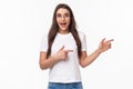 Waist-up portrait of excited, enthusiastic brunette 25s woman in t-shirt, jeans, pointing fingers right and look