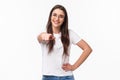 Waist-up portrait of happy smiling young woman inviting you join her team, recruit person, pointing finger at camera