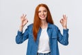 Waist-up portrait modern good-looking redhead girl in casual shirt, showing okay gestures and smiling, nod in approval