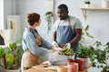 Multiethnic couple repotting exotic snake plant together in cozy setting