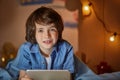 Joyous positive boy with tablet in nursery