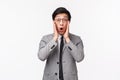 Waist-up portrait of shocked and amazed young speechless asian male entrepreneur in suit, drop jaw, gasping and saying Royalty Free Stock Photo