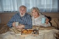 Horrified pensioners watching TV at home Royalty Free Stock Photo