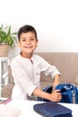 Waist up portrait of a smiling schoolboy. He collects a briefcase in school