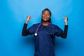 Waist up portrait of strong successful determined young African American doctor woman raising arms, clenching fists, exclaiming