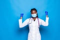 Waist up portrait of strong successful determined young African American doctor woman raising arms, clenching fists, exclaiming