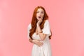 Waist-up portrait surprised and curious, astonished redhead girl heard amazing news, gossiping with girlfriend on party