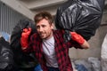 Man making efforts carrying while heavy garbage bags Royalty Free Stock Photo