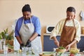 Two African American women cooking together in kitchen and doing food prep Royalty Free Stock Photo