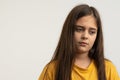 Waist up portrait of the upset, unhappy, sad brunette girl with loose hair, dressed in yellow t-shirt isolated over Royalty Free Stock Photo