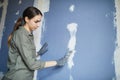 Young Woman Smoothing Dry Wall