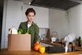 Woman unpacking fresh grocery delivery in kitchen
