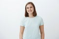 Waist-up shot of ambitious happy and cute female brunette in trendy t-shirt smiling joyfully being delighted and pleased