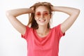 Waist-up shot of carefree energized and cute ginger woman with freckles and cute broad smile holding hair behind with