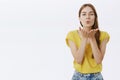 Waist-up shot of charming tender and feminine cutie in yellow t-shirt with pure skin and natural authentic look folding