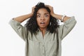 Waist-up shot of concerned girl in stupor. Portrait of shocked african american businesswoman standing anxious and Royalty Free Stock Photo