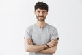 Waist-up shot of confident good-looking mature european male entrepreneur in t-shirt holding hands crossed in self