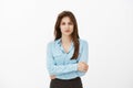 Waist-up shot of confident good-looking successful entrepreneur in blue blouse, holding hands together on chest and