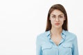 Waist-up shot of confident smart good-looking woman with brown hair in trendy glasses and blue blouse staring at camera Royalty Free Stock Photo