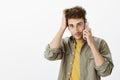 Waist-up shot of cute friendly-looking mature male coworker with blue eyes and bristle, talking on smartphone