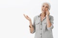 Waist-up shot of delighted caefree kind grandmother talking on telephone and gesturing while being excited and carried