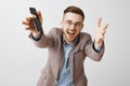 Waist-up shot of energized ambitious and emotive handsome guy with bristle in glasses and jacket pulling hands towards