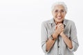 Waist-up shot of excited enthusiastic and happy elderly woman in glasses and shirt clenching palms together over chest
