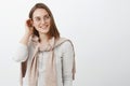 Waist-up shot of feminine creative and charming young girl in glasses and pullover knitten on neck putting hair strand