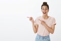 Waist-up shot of happy enthusiastic and excited joyful attractive european female with tan and messy hairbun smiling