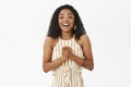 Waist-up shot of pleased and delighted happy young african american successful businesswoman in elegant striped yellow