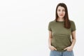 Waist-up shot of trustworthy calm and cute friendly-looking young 20s woman holding hands in pockets relaxed and casual Royalty Free Stock Photo