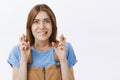 Waist-up shot of worried anxious cute female with brown hair in blue t-shirt biting lower lip from nerves frowning