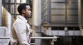 Waist up side view of young black businessman walking past modern architecture in there city, London UK Royalty Free Stock Photo