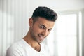 Happy young man is posing in room