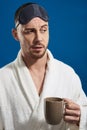 Waist up of young handsome man keeping mug with beverage in arm Royalty Free Stock Photo