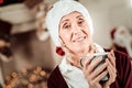 Pleasant senior woman holding a cup and smiling. Royalty Free Stock Photo